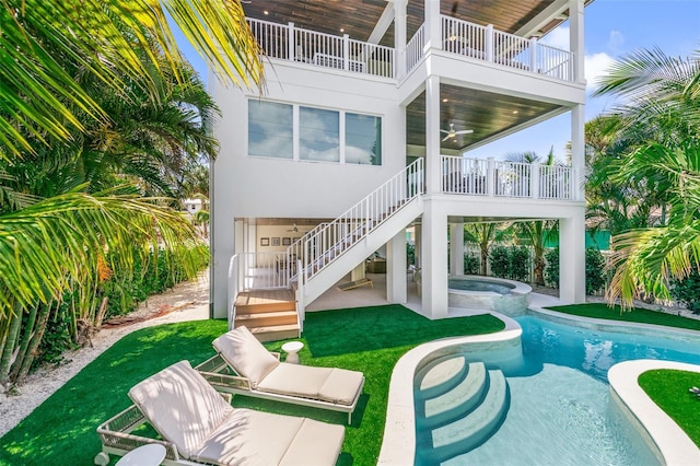 311 Spring Ave, Anna Maria, FL 34216 - back of house with an in ground hot tub, stairway, stucco siding, a patio, and an outdoor pool