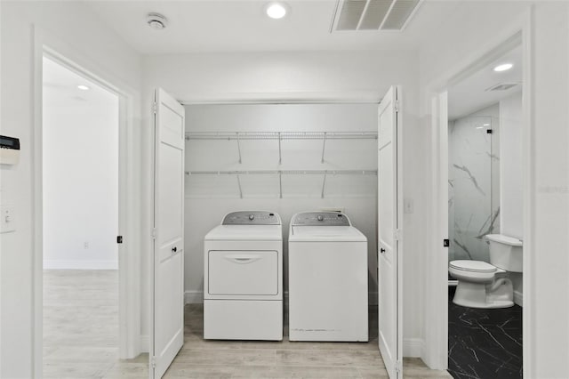 laundry area featuring visible vents, light wood-style flooring, washer and dryer, and laundry area