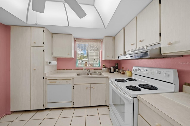 kitchen featuring light countertops, a sink, under cabinet range hood, and white appliances