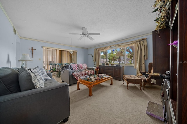 carpeted living area featuring a textured ceiling, visible vents, ornamental molding, and a ceiling fan