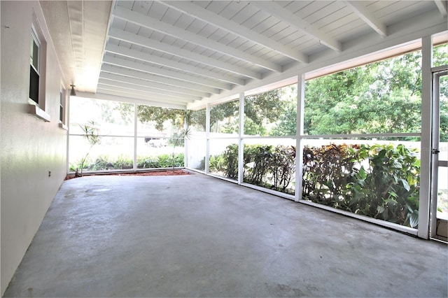 unfurnished sunroom featuring beam ceiling