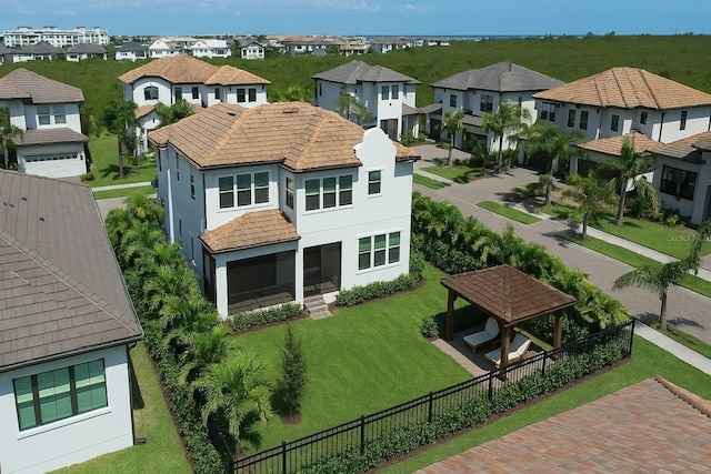 back of property featuring a gazebo, a residential view, fence private yard, and stucco siding