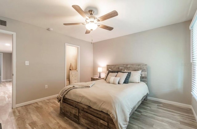 bedroom with baseboards, visible vents, a ceiling fan, and light wood finished floors