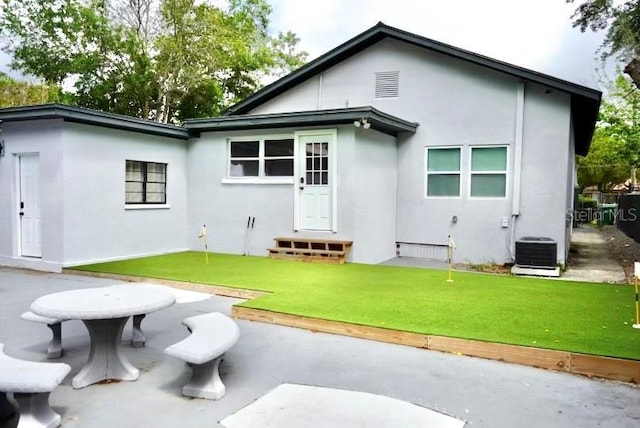 1515 E 31st Ave, Tampa, FL 33610 - rear view of house with stucco siding, central air condition unit, and entry steps