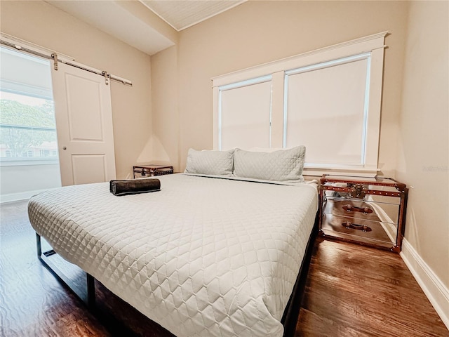1515 E 31st Ave, Tampa, FL 33610 - bedroom with baseboards, a barn door, and wood finished floors