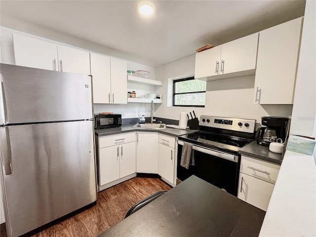 1515 E 31st Ave, Tampa, FL 33610 - kitchen with dark countertops, appliances with stainless steel finishes, white cabinetry, a sink, and dark wood-style floors