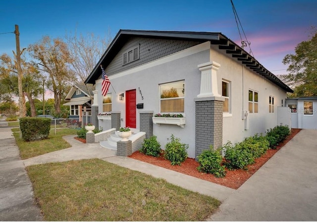 1515 E 31st Ave, Tampa, FL 33610 - view of front of property with brick siding, stucco siding, fence, and a lawn