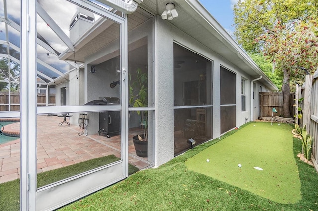 1419 Trail Boss Ln, Brandon, FL 33511 - fenced backyard featuring an area to practice putting, a patio area, a sunroom, and a lanai