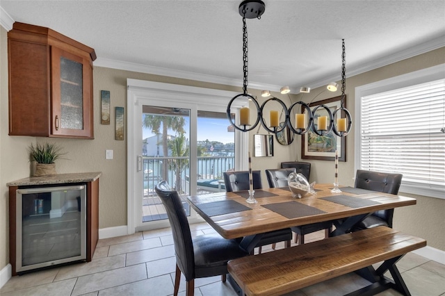 dining room with baseboards, crown molding, and beverage cooler