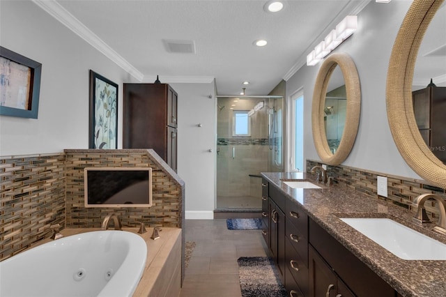 full bath with a sink, a whirlpool tub, crown molding, and a shower stall