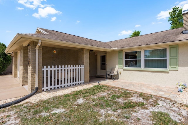 6831 Greenwich Ave, New Port Richey, FL 34653 - exterior space featuring a patio area, a chimney, stucco siding, brick siding, and a shingled roof