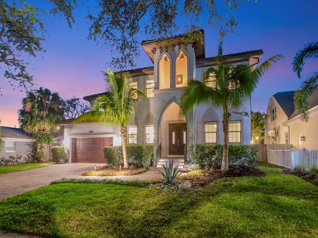 150 Chippewa Ave, Tampa, FL 33606 - mediterranean / spanish house featuring stucco siding, an attached garage, fence, and decorative driveway