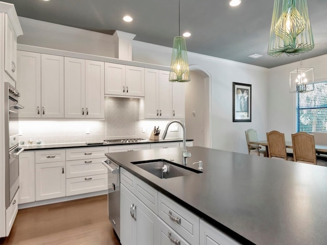 150 Chippewa Ave, Tampa, FL 33606 - kitchen featuring white cabinets, a sink, dark countertops, and stainless steel appliances