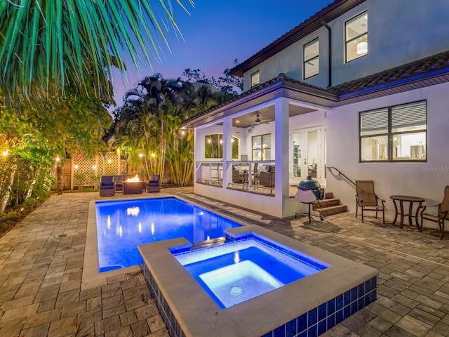 150 Chippewa Ave, Tampa, FL 33606 - pool at dusk with a fenced in pool, a fenced backyard, ceiling fan, an in ground hot tub, and a patio area