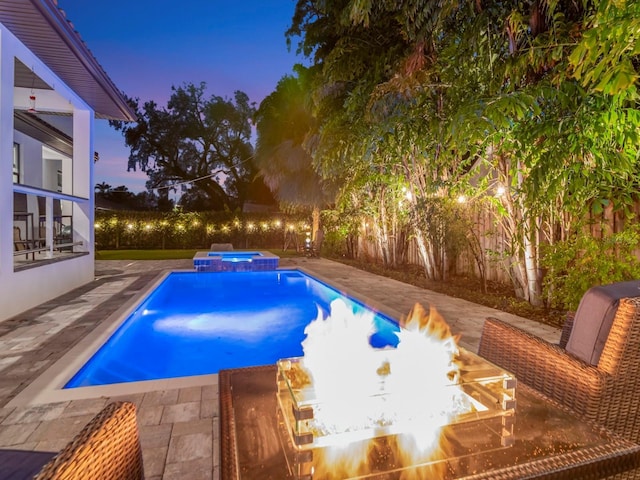 150 Chippewa Ave, Tampa, FL 33606 - pool at dusk with a fire pit, a pool with connected hot tub, and a patio