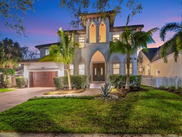 150 Chippewa Ave, Tampa, FL 33606 - mediterranean / spanish-style house with stucco siding, fence, french doors, driveway, and a lawn