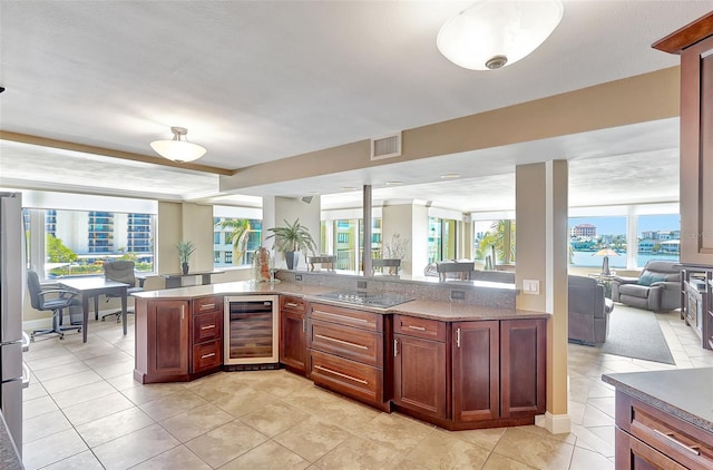 kitchen with visible vents, light tile patterned floors, black electric stovetop, open floor plan, and wine cooler