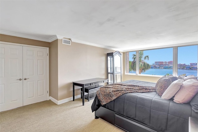 bedroom featuring crown molding, baseboards, visible vents, and light carpet