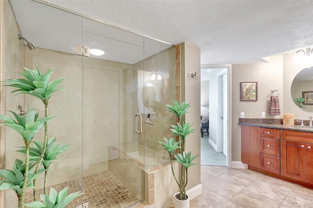 full bath with tile patterned flooring, a textured ceiling, a stall shower, and vanity