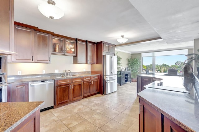 kitchen featuring a sink, glass insert cabinets, stainless steel appliances, and light tile patterned flooring