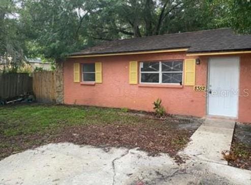 view of front of home with stucco siding and fence
