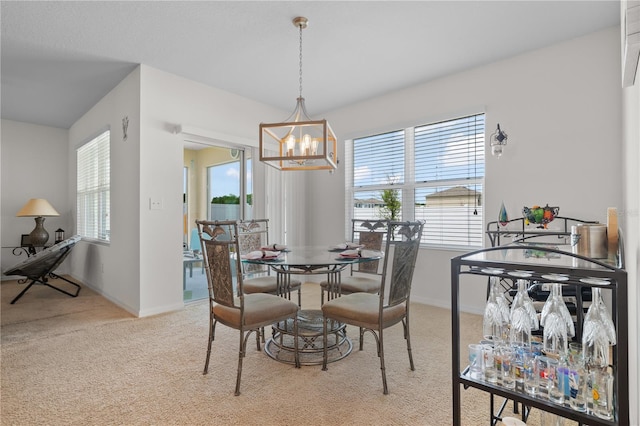 dining room with a notable chandelier, light colored carpet, a wealth of natural light, and baseboards