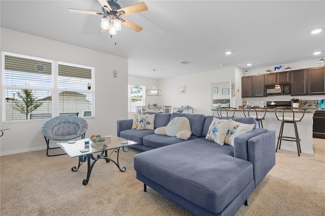 living area featuring light carpet, baseboards, a ceiling fan, and recessed lighting