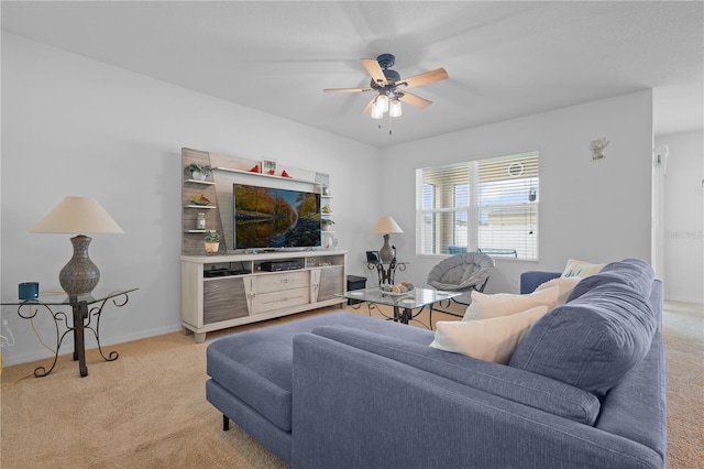 living area with ceiling fan, light carpet, and baseboards