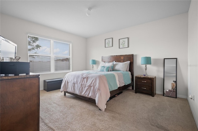 bedroom with baseboards and light colored carpet