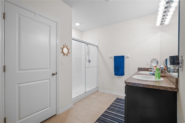 full bathroom featuring tile patterned floors, baseboards, a shower stall, and double vanity