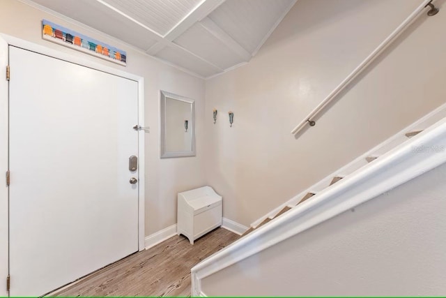 entrance foyer with light wood finished floors, baseboards, and stairs