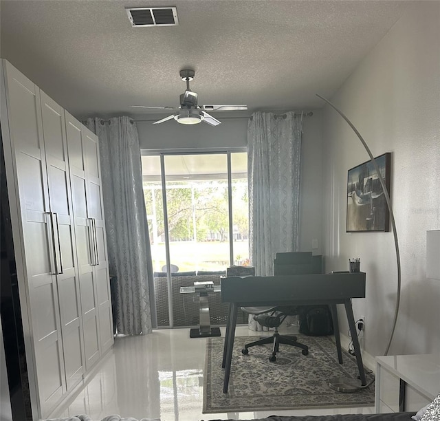 office area with visible vents, ceiling fan, and a textured ceiling