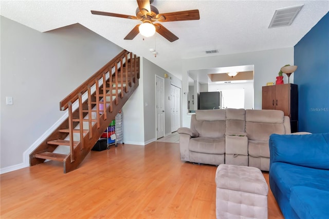 14053 Notreville Way, Tampa, FL 33624 - living area featuring ceiling fan, visible vents, stairway, and wood finished floors