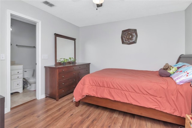 14053 Notreville Way, Tampa, FL 33624 - bedroom featuring wood finished floors, connected bathroom, ceiling fan, and visible vents
