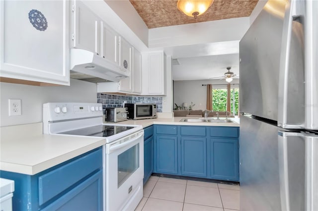14053 Notreville Way, Tampa, FL 33624 - kitchen featuring under cabinet range hood, blue cabinets, a sink, and stainless steel appliances