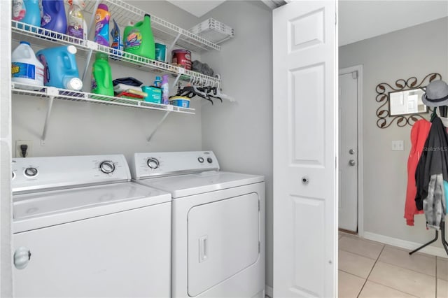 14053 Notreville Way, Tampa, FL 33624 - laundry area featuring baseboards, washing machine and dryer, laundry area, and light tile patterned floors
