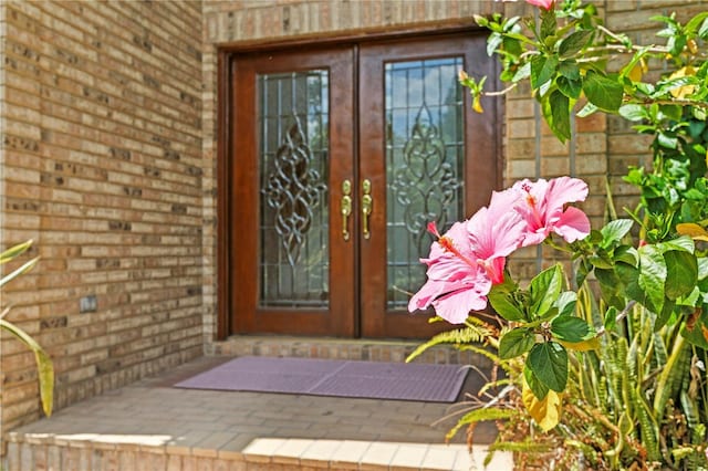entrance to property with brick siding and french doors
