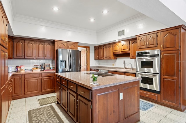 kitchen featuring a sink, stainless steel appliances, visible vents, a kitchen island, and ornamental molding