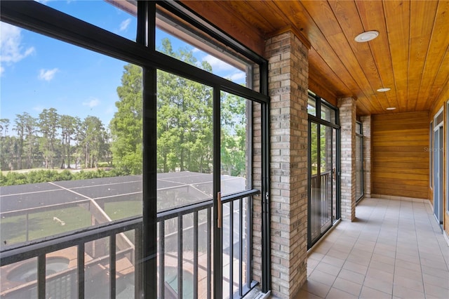 unfurnished sunroom featuring tile patterned floors, wooden ceiling, wooden walls, and recessed lighting