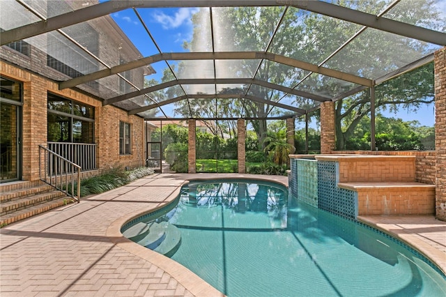 outdoor pool featuring a patio area and glass enclosure