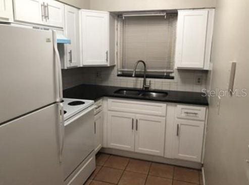 1733 Grand Blvd, Holiday, FL 34690 - kitchen with a sink, white appliances, white cabinets, and dark countertops