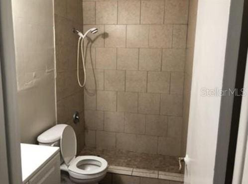 1733 Grand Blvd, Holiday, FL 34690 - bathroom with vanity, a tile shower, and toilet