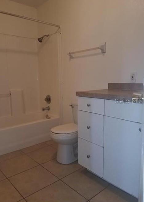1733 Grand Blvd, Holiday, FL 34690 - full bathroom with tile patterned floors, shower / bathtub combination, vanity, and toilet