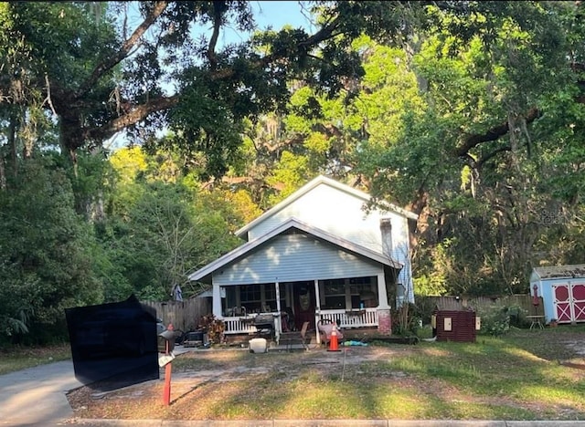 444 N Lemon Ave, Brooksville, FL 34601 - rear view of house featuring a storage shed, an outdoor structure, fence, and covered porch