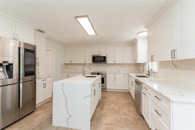 14319 Morristown Ave, Port Charlotte, FL 33981 - kitchen featuring stainless steel appliances, a sink, backsplash, and a center island with sink