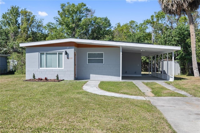 7139 Adare Dr, New Port Richey, FL 34653 - view of front of home featuring a front lawn, concrete block siding, a carport, and concrete driveway