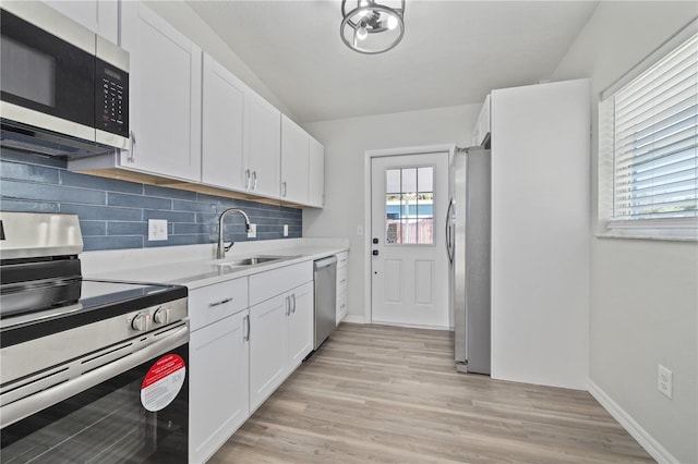 7139 Adare Dr, New Port Richey, FL 34653 - kitchen with light countertops, decorative backsplash, a sink, white cabinets, and appliances with stainless steel finishes