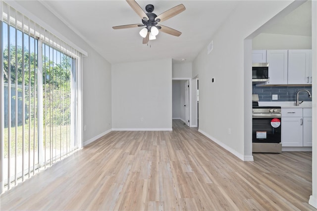 7139 Adare Dr, New Port Richey, FL 34653 - unfurnished living room featuring visible vents, baseboards, ceiling fan, a sink, and light wood-style floors