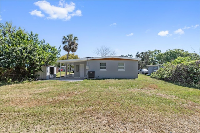 7139 Adare Dr, New Port Richey, FL 34653 - rear view of house featuring central air condition unit, a shed, an outdoor structure, a carport, and a lawn