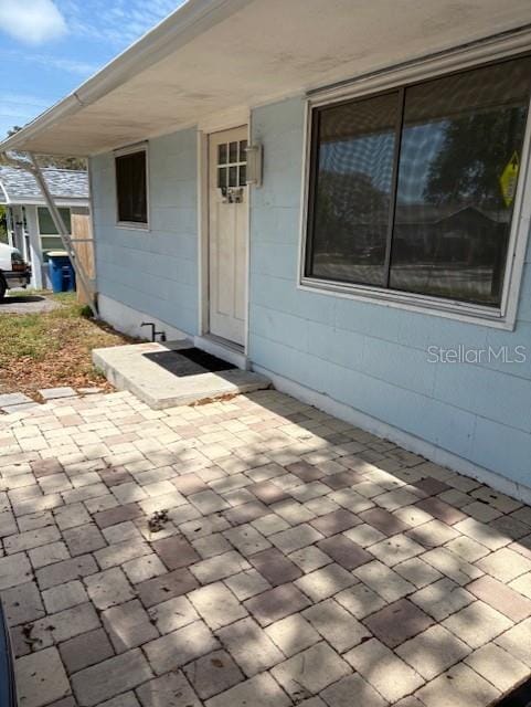 1408 San Juan Ct, Clearwater, FL 33756 - view of exterior entry featuring a patio area and concrete block siding